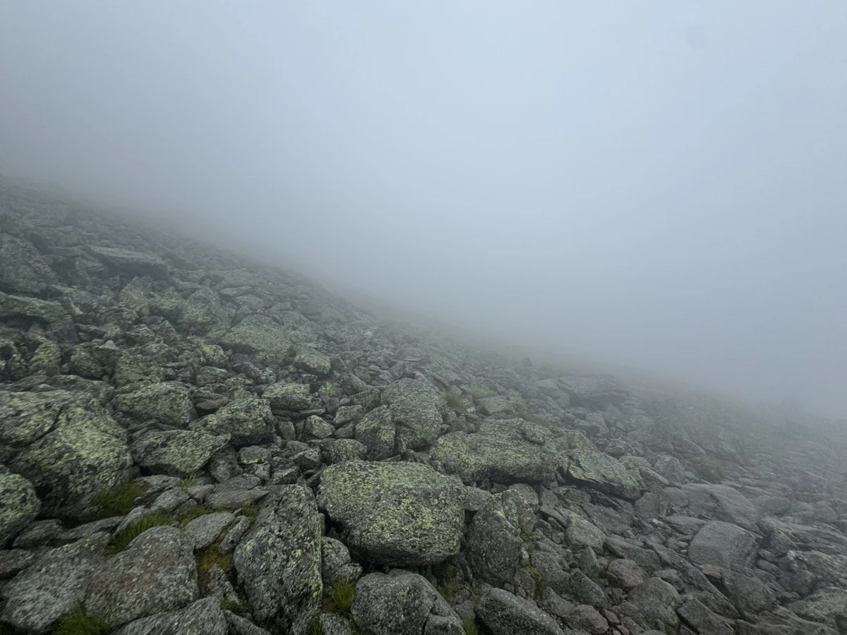 A rocky Mount Washington trail disappearing into thick fog